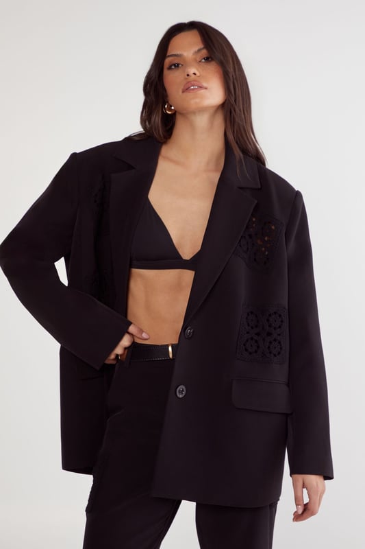 Tailored trousers featuring intricate crochet inserts at the knees for a distinctive design element
        Flattering flared silhouette that gracefully widens from the knee to create an elongated leg line
        High-rise waistband with belt loops, perfect for styling with statement belts
        Sleek side pockets for practical functionality without compromising on style
        Versatile design that transitions seamlessly from daytime sophistication to evening elegance
    
    These Nasty Gal tailored trousers redefine smart dressing with their artful crochet inserts that add textural interest to a classic silhouette. The flared leg creates a balanced proportion that flatters all figures, whilst the high-rise fit accentuates the waist beautifully. Style them as seen with an oversized blazer and minimal top for a contemporary take on tailoring, or pair with a crisp button-down shirt for more formal settings. The trousers work brilliantly for sophisticated events where you want to make an impression without appearing overdressed. For evening occasions, team with a silk camisole and strappy heels, or dress down for smart-casual gatherings with a fitted turtleneck and elegant flats. The crochet detail ensures these trousers stand out from standard tailoring, making them a versatile investment piece for your wardrobe.