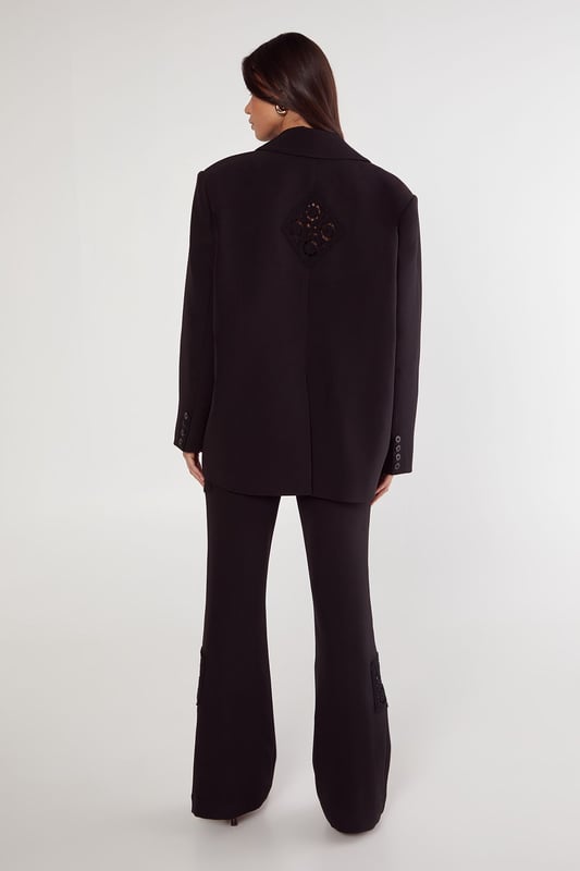 Tailored trousers featuring intricate crochet inserts at the knees for a distinctive design element
        Flattering flared silhouette that gracefully widens from the knee to create an elongated leg line
        High-rise waistband with belt loops, perfect for styling with statement belts
        Sleek side pockets for practical functionality without compromising on style
        Versatile design that transitions seamlessly from daytime sophistication to evening elegance
    
    These Nasty Gal tailored trousers redefine smart dressing with their artful crochet inserts that add textural interest to a classic silhouette. The flared leg creates a balanced proportion that flatters all figures, whilst the high-rise fit accentuates the waist beautifully. Style them as seen with an oversized blazer and minimal top for a contemporary take on tailoring, or pair with a crisp button-down shirt for more formal settings. The trousers work brilliantly for sophisticated events where you want to make an impression without appearing overdressed. For evening occasions, team with a silk camisole and strappy heels, or dress down for smart-casual gatherings with a fitted turtleneck and elegant flats. The crochet detail ensures these trousers stand out from standard tailoring, making them a versatile investment piece for your wardrobe.