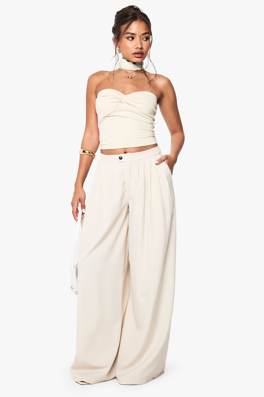 Dramatic extreme wide-leg design creates a flowing, statement silhouette
        High-waisted fit with button fastening for a secure and flattering shape
        Side pockets add practical functionality to this fashion-forward piece
        Soft fabric with slight stretch ensures comfort throughout the day
        Versatile trousers that can be styled for multiple occasions with ease
    
    Make a bold fashion statement with these eye-catching extreme wide-leg trousers from Boohoo. The dramatic flowing silhouette creates movement with every step whilst the high-waisted design accentuates your natural waistline for a flattering look. As seen on our model, pair with a coordinating bandeau top for a chic co-ord effect that's perfect for summer socials. For casual daytime wear, style with a fitted tee and trainers, or dress up with a bodysuit and heels for evening drinks. The neutral tone makes these trousers incredibly versatile for mixing and matching with your existing wardrobe favourites. The addition of practical side pockets enhances the wearability of this standout piece, making it as functional as it is fashionable for family gatherings and casual outings alike.