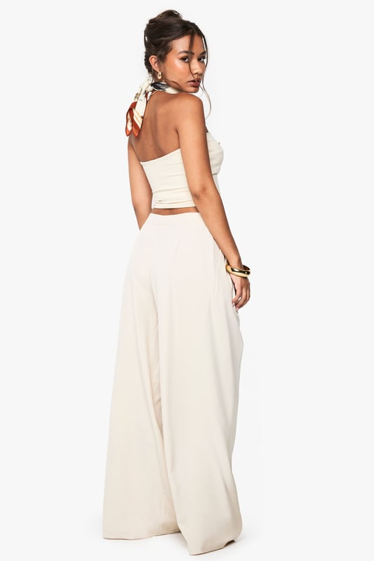 Dramatic extreme wide-leg design creates a flowing, statement silhouette
        High-waisted fit with button fastening for a secure and flattering shape
        Side pockets add practical functionality to this fashion-forward piece
        Soft fabric with slight stretch ensures comfort throughout the day
        Versatile trousers that can be styled for multiple occasions with ease
    
    Make a bold fashion statement with these eye-catching extreme wide-leg trousers from Boohoo. The dramatic flowing silhouette creates movement with every step whilst the high-waisted design accentuates your natural waistline for a flattering look. As seen on our model, pair with a coordinating bandeau top for a chic co-ord effect that's perfect for summer socials. For casual daytime wear, style with a fitted tee and trainers, or dress up with a bodysuit and heels for evening drinks. The neutral tone makes these trousers incredibly versatile for mixing and matching with your existing wardrobe favourites. The addition of practical side pockets enhances the wearability of this standout piece, making it as functional as it is fashionable for family gatherings and casual outings alike.