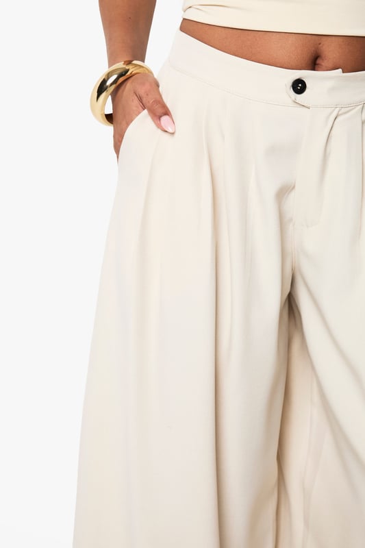 Dramatic extreme wide-leg design creates a flowing, statement silhouette
        High-waisted fit with button fastening for a secure and flattering shape
        Side pockets add practical functionality to this fashion-forward piece
        Soft fabric with slight stretch ensures comfort throughout the day
        Versatile trousers that can be styled for multiple occasions with ease
    
    Make a bold fashion statement with these eye-catching extreme wide-leg trousers from Boohoo. The dramatic flowing silhouette creates movement with every step whilst the high-waisted design accentuates your natural waistline for a flattering look. As seen on our model, pair with a coordinating bandeau top for a chic co-ord effect that's perfect for summer socials. For casual daytime wear, style with a fitted tee and trainers, or dress up with a bodysuit and heels for evening drinks. The neutral tone makes these trousers incredibly versatile for mixing and matching with your existing wardrobe favourites. The addition of practical side pockets enhances the wearability of this standout piece, making it as functional as it is fashionable for family gatherings and casual outings alike.
