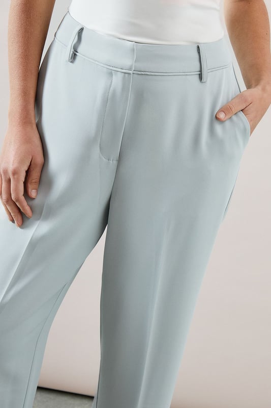Tapered design creates a flattering silhouette that narrows towards the ankle
        Smooth woven fabric with added stretch for day-long comfort
        Clean front seam detail adds a sophisticated touch
        Side pockets provide practical functionality
        Versatile ankle-length cut perfect for showcasing statement footwear
    
    These elegant tapered trousers from Wallis combine sophistication with everyday comfort. The streamlined silhouette offers a contemporary look whilst maintaining a relaxed feel, making them ideal for various daytime occasions. Style them as shown with a button-detail top for family gatherings or weekend brunches. The ankle-length cut pairs beautifully with strappy sandals during warmer months or with ballet flats and a lightweight jumper for cooler days. For a polished casual look, team with a tucked-in blouse and a structured tote bag. The versatile design transitions effortlessly from office to casual outings, whilst the added stretch ensures comfort throughout the day. These trousers are a wardrobe essential that will complement numerous existing pieces in your collection.