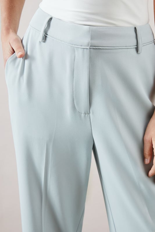 Tapered design creates a flattering silhouette that narrows towards the ankle
        Smooth woven fabric with added stretch for day-long comfort
        Clean front seam detail adds a sophisticated touch
        Side pockets provide practical functionality
        Versatile ankle-length cut perfect for showcasing statement footwear
    
    These elegant tapered trousers from Wallis combine sophistication with everyday comfort. The streamlined silhouette offers a contemporary look whilst maintaining a relaxed feel, making them ideal for various daytime occasions. Style them as shown with a button-detail top for family gatherings or weekend brunches. The ankle-length cut pairs beautifully with strappy sandals during warmer months or with ballet flats and a lightweight jumper for cooler days. For a polished casual look, team with a tucked-in blouse and a structured tote bag. The versatile design transitions effortlessly from office to casual outings, whilst the added stretch ensures comfort throughout the day. These trousers are a wardrobe essential that will complement numerous existing pieces in your collection.