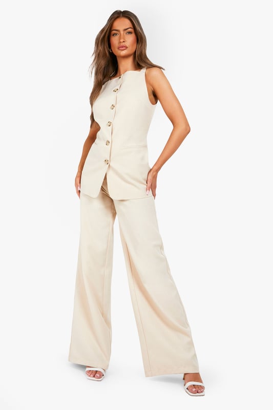 Textured woven fabric with distinctive structured finish for added visual interest
        High-waisted design with elegant button fastening for a flattering silhouette
        Straight leg cut with full-length wide profile for contemporary styling
        Clean, minimalist design perfect for versatile wardrobe integration
        Comfortable fit with generous leg room for all-day wearability
    
    These structured straight-leg trousers from Boohoo offer the perfect balance of comfort and contemporary style. The textured fabric adds subtle dimension to your look while the high-waisted design creates a flattering shape that works brilliantly with both fitted and oversized tops. Style them as shown with a simple white t-shirt for casual daytime outings, or dress them up with a fitted blouse and blazer for more polished occasions. The generous wide-leg silhouette provides excellent movement while maintaining a clean line from hip to hem. These trousers work beautifully with trainers for a relaxed weekend look or pair them with loafers for family gatherings. Their versatility makes them an essential wardrobe staple that transitions effortlessly from casual coffee dates to smart-casual office environments with just a simple change of accessories.