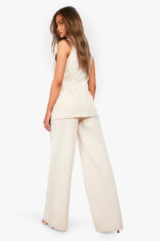 Textured woven fabric with distinctive structured finish for added visual interest
        High-waisted design with elegant button fastening for a flattering silhouette
        Straight leg cut with full-length wide profile for contemporary styling
        Clean, minimalist design perfect for versatile wardrobe integration
        Comfortable fit with generous leg room for all-day wearability
    
    These structured straight-leg trousers from Boohoo offer the perfect balance of comfort and contemporary style. The textured fabric adds subtle dimension to your look while the high-waisted design creates a flattering shape that works brilliantly with both fitted and oversized tops. Style them as shown with a simple white t-shirt for casual daytime outings, or dress them up with a fitted blouse and blazer for more polished occasions. The generous wide-leg silhouette provides excellent movement while maintaining a clean line from hip to hem. These trousers work beautifully with trainers for a relaxed weekend look or pair them with loafers for family gatherings. Their versatility makes them an essential wardrobe staple that transitions effortlessly from casual coffee dates to smart-casual office environments with just a simple change of accessories.