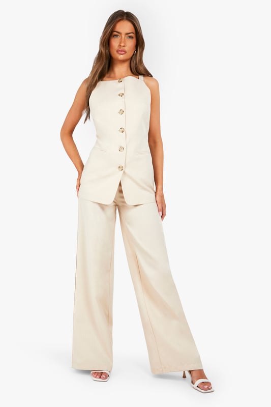 Textured woven fabric with distinctive structured finish for added visual interest
        High-waisted design with elegant button fastening for a flattering silhouette
        Straight leg cut with full-length wide profile for contemporary styling
        Clean, minimalist design perfect for versatile wardrobe integration
        Comfortable fit with generous leg room for all-day wearability
    
    These structured straight-leg trousers from Boohoo offer the perfect balance of comfort and contemporary style. The textured fabric adds subtle dimension to your look while the high-waisted design creates a flattering shape that works brilliantly with both fitted and oversized tops. Style them as shown with a simple white t-shirt for casual daytime outings, or dress them up with a fitted blouse and blazer for more polished occasions. The generous wide-leg silhouette provides excellent movement while maintaining a clean line from hip to hem. These trousers work beautifully with trainers for a relaxed weekend look or pair them with loafers for family gatherings. Their versatility makes them an essential wardrobe staple that transitions effortlessly from casual coffee dates to smart-casual office environments with just a simple change of accessories.