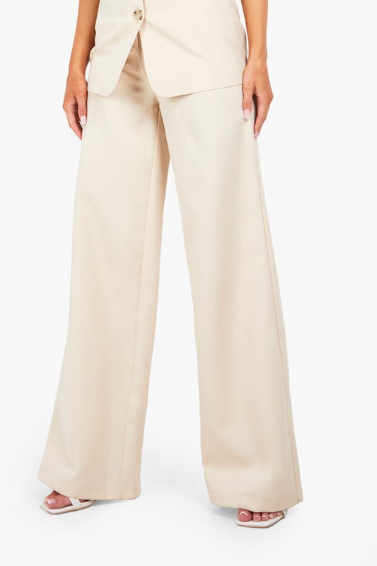 Textured woven fabric with distinctive structured finish for added visual interest
        High-waisted design with elegant button fastening for a flattering silhouette
        Straight leg cut with full-length wide profile for contemporary styling
        Clean, minimalist design perfect for versatile wardrobe integration
        Comfortable fit with generous leg room for all-day wearability
    
    These structured straight-leg trousers from Boohoo offer the perfect balance of comfort and contemporary style. The textured fabric adds subtle dimension to your look while the high-waisted design creates a flattering shape that works brilliantly with both fitted and oversized tops. Style them as shown with a simple white t-shirt for casual daytime outings, or dress them up with a fitted blouse and blazer for more polished occasions. The generous wide-leg silhouette provides excellent movement while maintaining a clean line from hip to hem. These trousers work beautifully with trainers for a relaxed weekend look or pair them with loafers for family gatherings. Their versatility makes them an essential wardrobe staple that transitions effortlessly from casual coffee dates to smart-casual office environments with just a simple change of accessories.