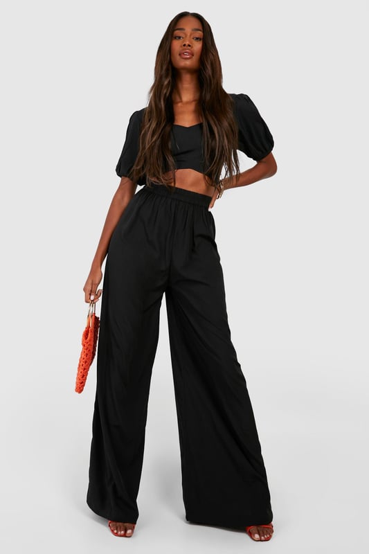 Wide leg palazzo design for a dramatic silhouette
        Pleated front detail adds texture and sophistication
        High-waisted fit elongates the legs
        Woven crepe fabric offers a luxurious drape
        Versatile style suitable for various casual occasions
    
    Make a statement with these eye-catching pleat front wide leg palazzo trousers. The dramatic silhouette created by the wide leg design is perfect for those who want to stand out from the crowd. The high-waisted fit not only accentuates your curves but also creates the illusion of longer legs. Pair these trousers with a cropped top, as shown in the image, for a trendy and balanced look. The woven crepe fabric ensures a beautiful drape that moves gracefully with every step. These trousers are ideal for casual events or family gatherings where you want to look effortlessly chic. For a laid-back daytime look, team them with trainers and a simple tee. When the evening calls for something more refined, swap the trainers for heeled sandals and add some statement jewellery to elevate your ensemble. The versatility of these trousers makes them a must-have addition to any fashion-forward wardrobe.
