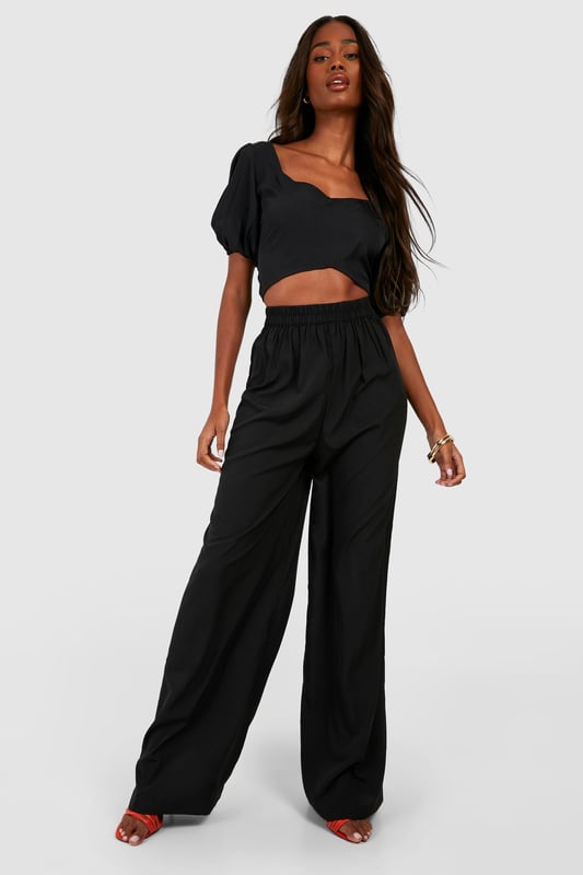 Wide leg palazzo design for a dramatic silhouette
        Pleated front detail adds texture and sophistication
        High-waisted fit elongates the legs
        Woven crepe fabric offers a luxurious drape
        Versatile style suitable for various casual occasions
    
    Make a statement with these eye-catching pleat front wide leg palazzo trousers. The dramatic silhouette created by the wide leg design is perfect for those who want to stand out from the crowd. The high-waisted fit not only accentuates your curves but also creates the illusion of longer legs. Pair these trousers with a cropped top, as shown in the image, for a trendy and balanced look. The woven crepe fabric ensures a beautiful drape that moves gracefully with every step. These trousers are ideal for casual events or family gatherings where you want to look effortlessly chic. For a laid-back daytime look, team them with trainers and a simple tee. When the evening calls for something more refined, swap the trainers for heeled sandals and add some statement jewellery to elevate your ensemble. The versatility of these trousers makes them a must-have addition to any fashion-forward wardrobe.