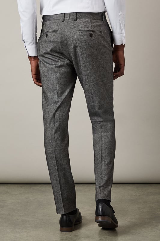 Distinctive herringbone pattern adds subtle texture and visual interest
        Slim fit design offers a contemporary silhouette that flatters the modern man
        Flat front styling creates a clean, streamlined appearance
        Back pockets with button closure for secure storage
        Versatile trousers that pair perfectly with matching suit pieces or as separates
    
    These Burton herringbone trousers present the perfect balance of classic tailoring and contemporary style. The slim fit contours to your frame without restricting movement, making them ideal for the gentleman who appreciates refined clothing with practical comfort. Style them as shown with a crisp white shirt for formal occasions, or dress them down with a lightweight jumper for smart-casual events. The versatile design transitions seamlessly from important business meetings to after-work drinks at the pub. Complete the look with polished Oxford shoes for traditional sophistication, or pair with smart Chelsea boots for a modern twist. These trousers serve as a cornerstone piece in any well-curated wardrobe, offering endless styling possibilities throughout the seasons.