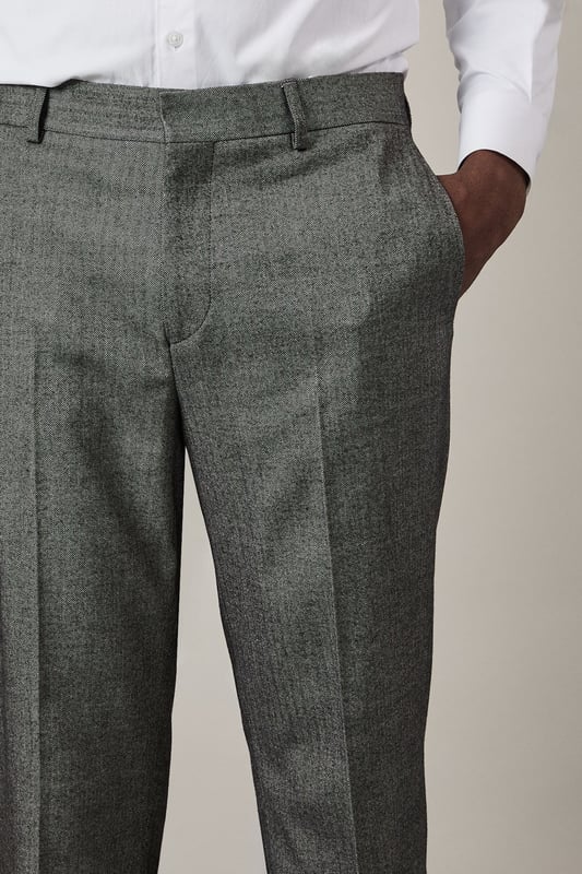Distinctive herringbone pattern adds subtle texture and visual interest
        Slim fit design offers a contemporary silhouette that flatters the modern man
        Flat front styling creates a clean, streamlined appearance
        Back pockets with button closure for secure storage
        Versatile trousers that pair perfectly with matching suit pieces or as separates
    
    These Burton herringbone trousers present the perfect balance of classic tailoring and contemporary style. The slim fit contours to your frame without restricting movement, making them ideal for the gentleman who appreciates refined clothing with practical comfort. Style them as shown with a crisp white shirt for formal occasions, or dress them down with a lightweight jumper for smart-casual events. The versatile design transitions seamlessly from important business meetings to after-work drinks at the pub. Complete the look with polished Oxford shoes for traditional sophistication, or pair with smart Chelsea boots for a modern twist. These trousers serve as a cornerstone piece in any well-curated wardrobe, offering endless styling possibilities throughout the seasons.