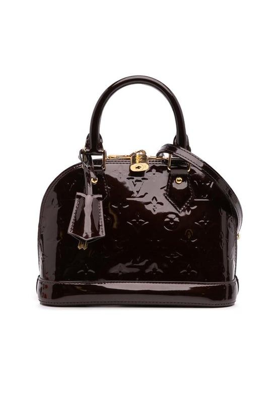 The Alma BB features a monogram vernis leather body a clochette rolled leather handles a top zip-around closure and an interior slip pocket.Brand: Louis VuittonCondition: Pre-lovedType: SatchelRating: B+Main Material: LeatherDimensions (LxWxD): 17.5x23.5x11.5Strap Drop: 56.5Handle Drop: 10.5Comments: Exterior Bottom Scratched. Exterior Handle Scratched. Interior Lining stained with Other. Practical Attachment Scratched. Exterior Top stained with Other. Zipper Scratched.