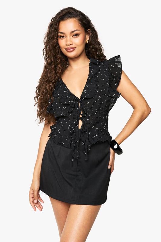 Flirty V-neckline with charming front tie detail for adjustable styling
        Feminine ruffle sleeves adding playful movement and dimension
        Delicate all-over floral print creating visual interest
        Loose fit design offering comfortable, relaxed silhouette
        Cropped length perfect for high-waisted bottoms
    
    This enchanting ruffle blouse from Boohoo brings carefree charm to your everyday wardrobe. The loose-fitting silhouette creates an effortlessly chic look whilst the front tie detail allows you to customise your neckline depth. Style with your favourite denim shorts and trainers for daytime outings, or pair with a fitted mini skirt as seen on our model for casual gatherings. The ruffle sleeve detailing adds a touch of femininity that works beautifully for family brunches or weekend coffee dates. For cooler evenings, layer under a lightweight denim jacket and finish with simple hoop earrings. The versatile design makes this blouse a true wardrobe hero that transitions seamlessly from casual park days to relaxed evening drinks with friends.