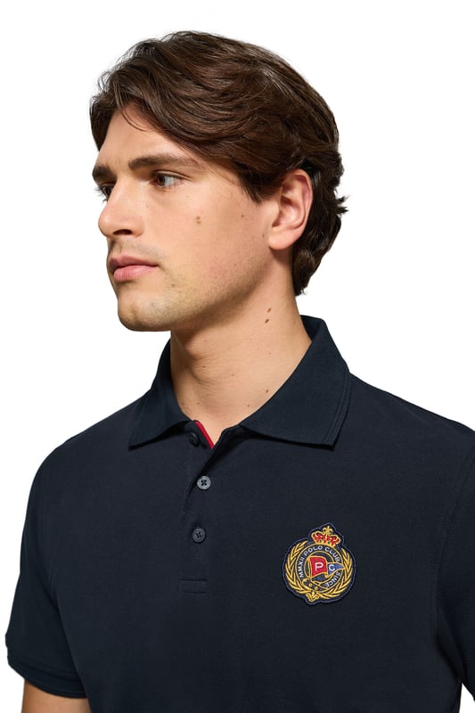 Peppen Sie Ihren Stil mit diesem kurzärmligen Herren-Poloshirt auf, das von der Seefahrt inspiriert ist. Es ist aus Baumwollpiqué gefertigt und verfügt über einen eleganten gerippten Kragen und drei farblich abgestimmte Logo-Knöpfe. Die dezenten Paspeln an der Knopfleiste unterstreichen seinen exklusiven Charakter. Kleine Seitenschlitze. Gerippte Ärmelbündchen sorgen für einen perfekten Sitz. Nahtband an der Krageninnenseite. Der maritim inspirierte Aufnäher auf der Brust und das gummierte Polo Club Etikett an der Seite sorgen für einen sportlichen Touch und bieten einen lässigen und zugleich stilvollen Look.