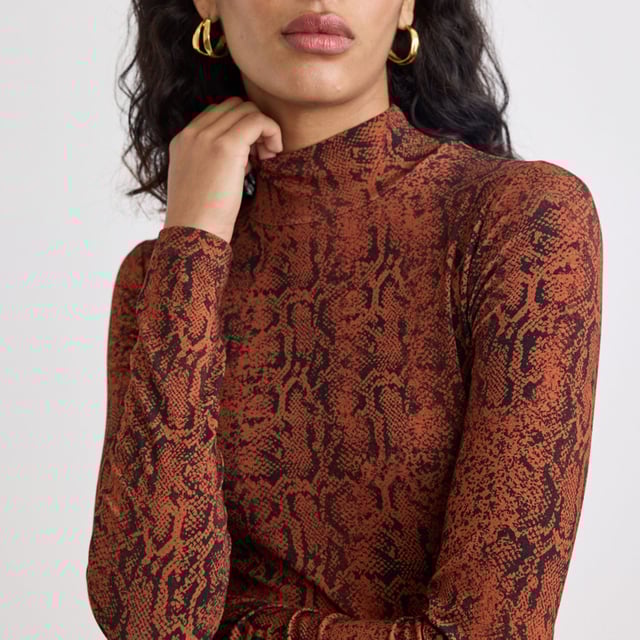 Women's Nobodys Child Lyra Snake Print Funnel Neck Long Sleeve Top. A true essential. With a high neckline and long sleeves, this brown snake print top is the perfect layering piece. Style with your favourite jeans or layer under pinnies, waistcoats, dungarees and more.- High neck.- Long sleeves.- Soft stretch jersey fabric.- Designed for a close cut.- Size tip: we recommend your usual size. Material: 95% Ecovero™ Viscose, 5% Elastane. Ref: T250945MLT.
