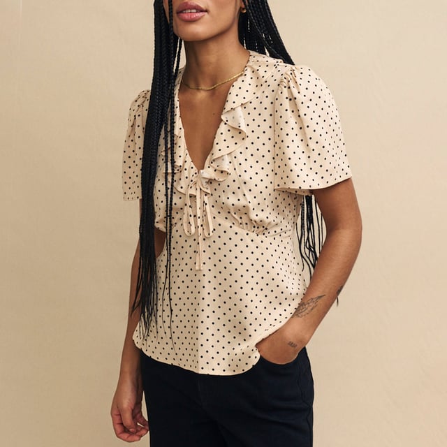 Women's Nobodys Child Joely Blouse. Every wardrobe needs a cute top like Joley. Woven entirely from responsible viscose, she’ll infuse a little vintage-inspired romance into your look with her fluted sleeves and floaty ruffles. We love the cream polka dot print and the figure-skimming fit. Style yours with black jeans.- V-neck.- Fluted sleeves.- Under bust seams designed to flatter.- String tie detail. Material: 100% Ecovero™ Viscose. Ref: T240662CRM.