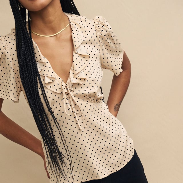 Women's Nobodys Child Joely Blouse. Every wardrobe needs a cute top like Joley. Woven entirely from responsible viscose, she’ll infuse a little vintage-inspired romance into your look with her fluted sleeves and floaty ruffles. We love the cream polka dot print and the figure-skimming fit. Style yours with black jeans.- V-neck.- Fluted sleeves.- Under bust seams designed to flatter.- String tie detail. Material: 100% Ecovero™ Viscose. Ref: T240662CRM.