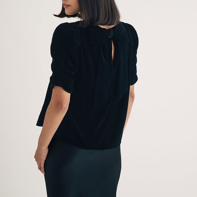 Women's Nobodys Child Velvet Gathered Sleeve Top. Your new favourite party top. Expertly crafted entirely from recycled materials, this classic black velvet number comes with pretty puff sleeves and a relaxed silhouette for comfort and style. Turn around to show off the statement bow and keyhole detailing at the back. Dress it down in the day with denim, or dazzle in a long slip skirt at night.- Crew neck.- Short puff sleeves.- Keyhole tie back fastening.- Designed for a relaxed fit. Material: 100% Polyester (Recycled). Ref: T241989BLK.