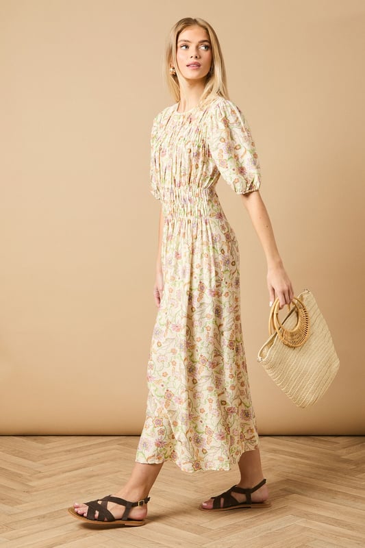 Beautifully shirred bodice creating a flattering silhouette
        Charming puff sleeves with elasticated cuffs for a feminine touch
        Elegant midi length perfect for day-to-evening versatility
        Crew neckline offering a classic, sophisticated finish
        All-over print design that adds visual interest to your wardrobe
    
    This delightful Oasis midi dress showcases the perfect blend of comfort and style with its intricately shirred bodice and charming puff sleeves. The flowing midi length creates an effortlessly feminine silhouette that's ideal for casual daywear occasions. Style with chunky sandals as shown for a contemporary daytime look, or pair with white trainers and a denim jacket for weekend brunches and family gatherings. The versatile design makes it perfect for garden parties or casual coffee dates with friends. For cooler days, layer with a lightweight cardigan and ankle boots to maintain that effortless charm. The shirred detailing adds texture while the all-over print ensures this piece will become a standout favourite in your wardrobe rotation.