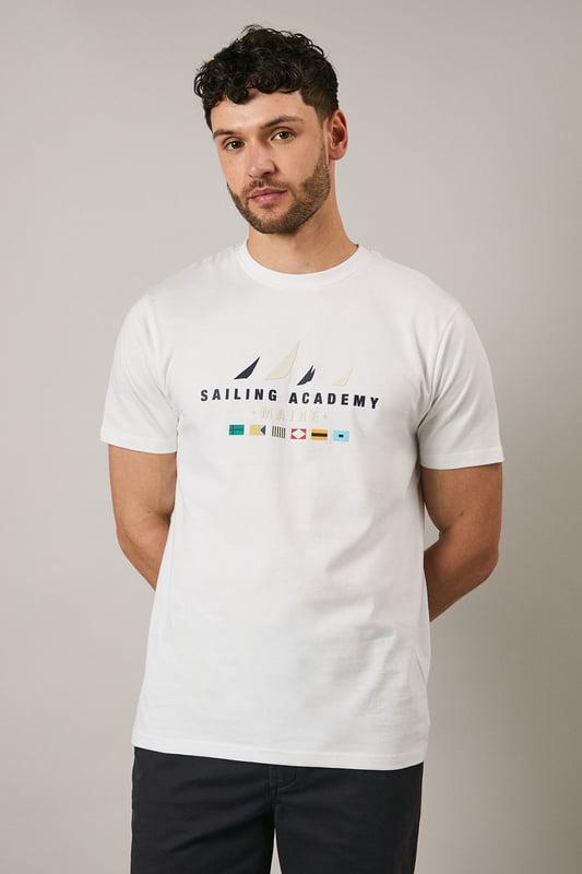 Classic crew neck t-shirt from Maine's Sailing Academy collection
        Soft cotton jersey fabric for all-day comfort
        Distinctive nautical graphic with sailing flags design
        Clean, minimalist back design for versatile styling
        Regular fit silhouette suitable for various body types
    
    This Maine Sailing Academy t-shirt combines casual comfort with maritime charm. The standout graphic featuring nautical flags brings a touch of seafaring style to your everyday wardrobe. As shown, it pairs perfectly with dark shorts and white trainers for a relaxed weekend look. The versatile design makes it ideal for coastal holidays, summer barbecues, or casual meet-ups with mates. Layer under a navy bomber jacket when the temperature drops or team with chinos and boat shoes for a smarter nautical-inspired ensemble. The clean-cut silhouette and breathable cotton fabric ensure you'll stay comfortable whether you're strolling along the harbour or enjoying a casual lunch at your local pub. A wardrobe essential that transitions effortlessly from daytime outings to laid-back evening gatherings.