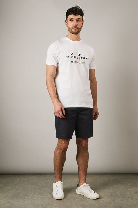 Classic crew neck t-shirt from Maine's Sailing Academy collection
        Soft cotton jersey fabric for all-day comfort
        Distinctive nautical graphic with sailing flags design
        Clean, minimalist back design for versatile styling
        Regular fit silhouette suitable for various body types
    
    This Maine Sailing Academy t-shirt combines casual comfort with maritime charm. The standout graphic featuring nautical flags brings a touch of seafaring style to your everyday wardrobe. As shown, it pairs perfectly with dark shorts and white trainers for a relaxed weekend look. The versatile design makes it ideal for coastal holidays, summer barbecues, or casual meet-ups with mates. Layer under a navy bomber jacket when the temperature drops or team with chinos and boat shoes for a smarter nautical-inspired ensemble. The clean-cut silhouette and breathable cotton fabric ensure you'll stay comfortable whether you're strolling along the harbour or enjoying a casual lunch at your local pub. A wardrobe essential that transitions effortlessly from daytime outings to laid-back evening gatherings.