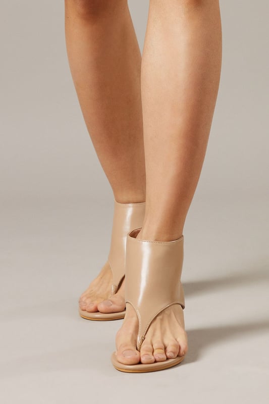 Distinctive toe post design with sleek faux leather finish
        Elegant kitten heel measuring between 5-6.5cm for comfortable all-day wear
        Convenient rear zip closure for easy on-off access
        Unique boot-sandal hybrid silhouette for versatile styling options
        Minimalist design with clean lines for effortless pairing with various outfits
    
    The Faith Candy Shoe Boots present a contemporary twist on traditional footwear, combining the coverage of an ankle boot with the breathability of a sandal. The innovative toe post detail adds a modern touch to these versatile heels, making them ideal for transitional weather. Style them with tailored shorts and an oversized blazer for a fashion-forward daytime look, or pair with cropped trousers and a fitted top for family gatherings. The modest kitten heel provides just enough elevation without sacrificing comfort, perfect for extended wear during casual outings or weekend brunches. These shoe boots shine when worn with minimalist ensembles, allowing their unique silhouette to make a subtle statement. Their adaptable nature makes them a valuable addition to any wardrobe, seamlessly taking you from day to evening casual events.