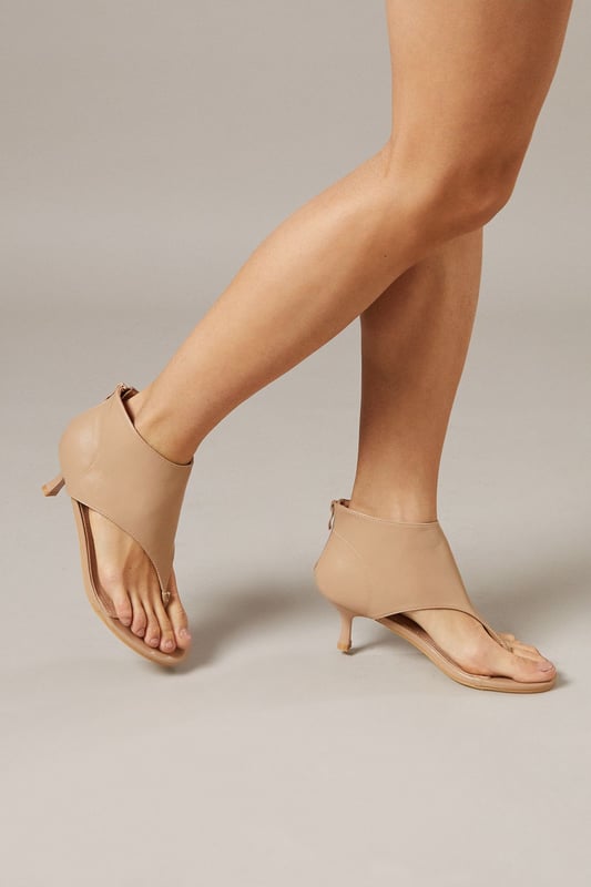 Distinctive toe post design with sleek faux leather finish
        Elegant kitten heel measuring between 5-6.5cm for comfortable all-day wear
        Convenient rear zip closure for easy on-off access
        Unique boot-sandal hybrid silhouette for versatile styling options
        Minimalist design with clean lines for effortless pairing with various outfits
    
    The Faith Candy Shoe Boots present a contemporary twist on traditional footwear, combining the coverage of an ankle boot with the breathability of a sandal. The innovative toe post detail adds a modern touch to these versatile heels, making them ideal for transitional weather. Style them with tailored shorts and an oversized blazer for a fashion-forward daytime look, or pair with cropped trousers and a fitted top for family gatherings. The modest kitten heel provides just enough elevation without sacrificing comfort, perfect for extended wear during casual outings or weekend brunches. These shoe boots shine when worn with minimalist ensembles, allowing their unique silhouette to make a subtle statement. Their adaptable nature makes them a valuable addition to any wardrobe, seamlessly taking you from day to evening casual events.