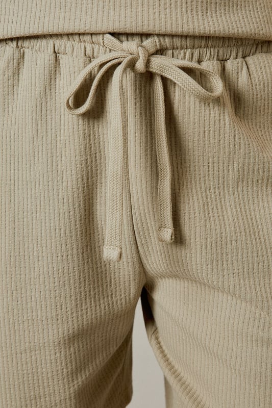 Distinctive seersucker texture adds visual interest and breathability to these casual shorts
        Comfortable elasticated waistband with adjustable drawstring for a personalised fit
        Relaxed leg shape offers ease of movement for all-day comfort
        Mid-thigh length provides a modern silhouette that works for various body types
        Cotton-rich fabric ensures these shorts remain soft and comfortable throughout the day
    
    These Burton seersucker shorts combine classic style with modern comfort, perfect for the man who appreciates timeless fashion. The textured fabric adds subtle sophistication while remaining thoroughly practical for warm-weather wear. Style them as shown with a matching polo shirt for a coordinated look that works brilliantly for weekend barbecues or casual pub gatherings with mates. Alternatively, pair with a crisp white t-shirt and trainers for an effortless daytime ensemble. The neutral tone makes these shorts incredibly versatile, allowing them to complement your existing wardrobe with ease. They're ideal for family gatherings, sporting events, or simply relaxing in the garden on sunny afternoons. Machine washable at 30 degrees, these shorts offer both style and practicality for the modern British man.