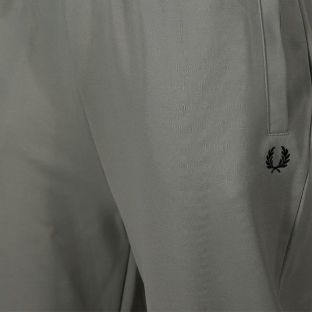 Veredeln Sie Ihre Freizeitgarderobe mit dieser exklusiven Fred Perry Seasonal Track Pants in atemberaubendem Seegras/Nachtgrün. Diese in Portugal mit höchster Präzision gefertigte Herren-Jogginghose verbindet anspruchsvollen Stil mit sportlicher Tradition. Das perfekte Statement-Piece für trendigen Komfort. 100 % Baumwolle