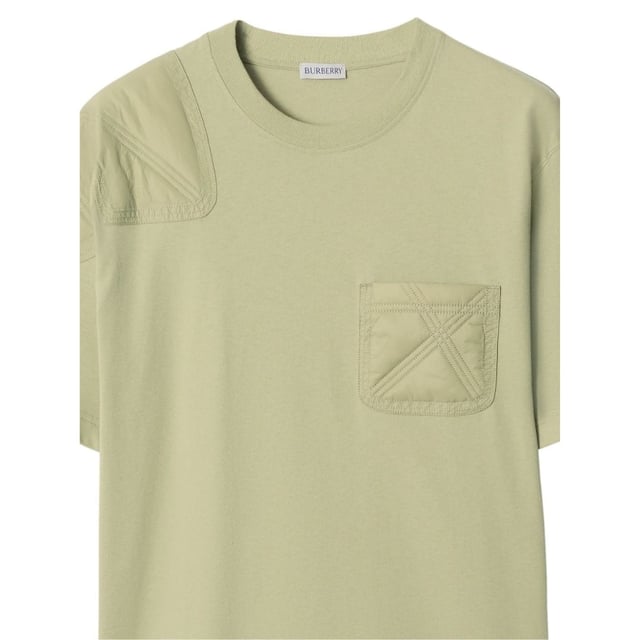 Camiseta verde cazador con paneles de jersey de Burberry Experimenta la comodidad y el estilo con la camiseta 100% algodón de Burberry. Con un práctico bolsillo en el pecho izquierdo y acolchado en el hombro derecho, además de un sutil monograma de Thomas Burberry en la espalda izquierda, esta camiseta es perfecta para quienes aprecian los detalles finos en sus elecciones de moda. ¡Añádela a tu armario y realza tu look diario!