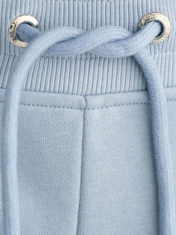 These classic sweat shorts are crafted from a soft cotton blend and tailored for a regular fit. Featuring a ribbed waistband for enhanced comfort, the design includes two front pockets, a single back pocket, and a drawstring waist. Completing the look, the shorts are adorned with a small-scale shield graphic embroidered on the left leg.