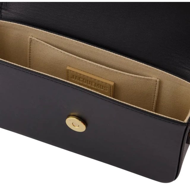 Jacquemus Le Carinu Black Bag is the epitome of contemporary luxury that every fashion-forward woman deserves. This sleek designer accessory combines minimalist French aesthetics with practical functionality. The sophisticated black finish ensures versatility with any outfit, from casual daywear to elegant evening ensembles. Crafted with meticulous attention to detail, this coveted piece instantly elevates your style credentials while offering the perfect size for your essentials. Don't miss the opportunity to own this season's must-have accessory. Dimensions: 12 x 18.5cm. 100% Leather Made In Spain