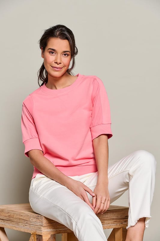 Deze pastelroze Calgary sweater brengt een frisse kleurboost aan je lente- en zomeroutfit. De sweater is gemaakt van twee verschillende katoenen materialen. De luchtige geweven katoenen mouwen zorgen voor een verrassend effect, terwijl de korte mouwen met ribboord een stoere uitstraling hebben. Zowel de ronde halslijn als de taillezoom zijn afgewerkt met een zachte ribboord, wat een casual look geeft. Een sportief element wordt toegevoegd door het V-vormige stiksel bij de halslijn op het voorpand. De doorgestikte naden op de mouwen lopen door tot aan de schouders, wat de mouwen accentueert.Door de combinatie van materialen is deze sweater een uniek item dat het beste van een sweater en blouse combineert. Draag de Calgary short sleeve sweater op een frisse lentedag met het stoere Montreal jasje. De luchtige katoenen materialen maken het ook ideaal voor warmer weer. Style de sweater met mooie sieraden om de sportieve top een chique en geklede uitstraling te geven.