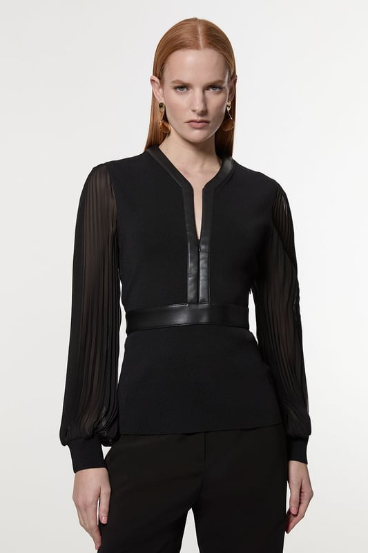 This Karen Millen top seamlessly blends sophistication with contemporary style. The knitted body offers a sleek fit, while the pleated woven sleeves add a touch of drama and movement. The faux leather trim along the V-neckline and waistband creates a striking contrast, enhancing the overall silhouette. Perfect for both day and evening wear, this top can be styled with tailored trousers and heels for a formal event, or paired with a pencil skirt for an office look. The versatility of this piece allows for endless styling possibilities, making it a valuable addition to any wardrobe. Whether you're attending a wedding, a cocktail party, or a business meeting, this top will ensure you look polished and fashion-forward.  Elegant V-neck design with faux leather trim Pleated woven sleeves for added texture Knitted body with a fitted silhouette Faux leather waistband for a defined shape Versatile piece suitable for various occasions