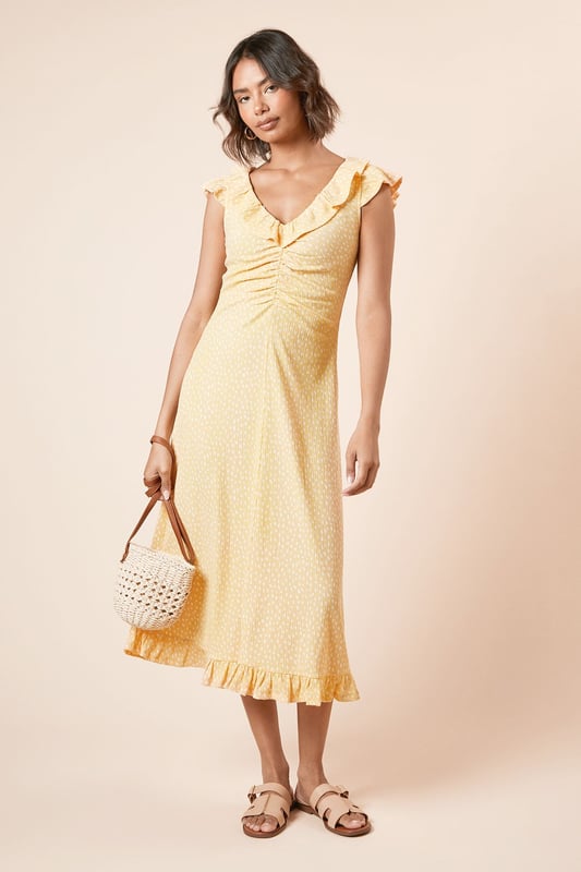Feminine frill neckline with delicate ruffle detail for a soft, romantic touch
        Flattering ruched front design that gently contours the silhouette
        Midi length with pretty frill hem for added movement and charm
        Comfortable stretch woven fabric that moves with you throughout the day
        Versatile V-neckline that frames the dcolletage beautifully
    
    This charming spotted midi dress from Dorothy Perkins strikes the perfect balance between casual comfort and feminine style. The ruched front creates a flattering silhouette that complements all figures, whilst the frill neckline adds a touch of playfulness to your look. Style with flat sandals and a woven basket bag for weekend brunches with the girls, or dress up with espadrille wedges for garden parties and family gatherings. The midi length offers modest coverage whilst remaining thoroughly modern, making it an ideal choice for baby showers or afternoon tea. For cooler days, layer with a lightweight cardigan and pair with white trainers for an effortlessly chic ensemble. This versatile piece transitions seamlessly from daytime casual to evening drinks - simply swap your accessories to customise your look for any occasion.