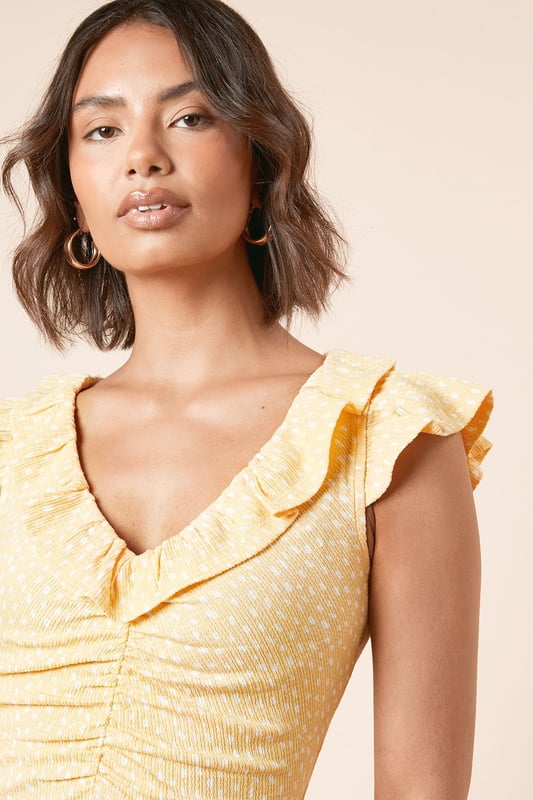 Feminine frill neckline with delicate ruffle detail for a soft, romantic touch
        Flattering ruched front design that gently contours the silhouette
        Midi length with pretty frill hem for added movement and charm
        Comfortable stretch woven fabric that moves with you throughout the day
        Versatile V-neckline that frames the dcolletage beautifully
    
    This charming spotted midi dress from Dorothy Perkins strikes the perfect balance between casual comfort and feminine style. The ruched front creates a flattering silhouette that complements all figures, whilst the frill neckline adds a touch of playfulness to your look. Style with flat sandals and a woven basket bag for weekend brunches with the girls, or dress up with espadrille wedges for garden parties and family gatherings. The midi length offers modest coverage whilst remaining thoroughly modern, making it an ideal choice for baby showers or afternoon tea. For cooler days, layer with a lightweight cardigan and pair with white trainers for an effortlessly chic ensemble. This versatile piece transitions seamlessly from daytime casual to evening drinks - simply swap your accessories to customise your look for any occasion.