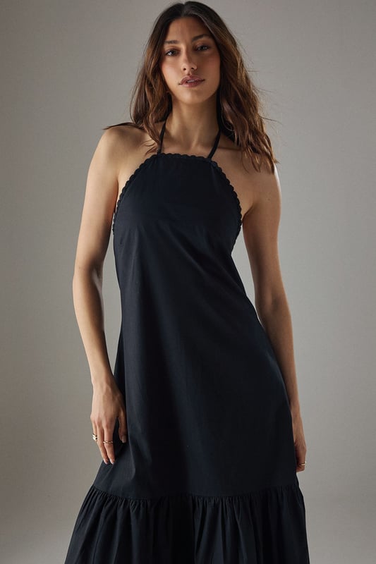 Crafted from breathable cotton poplin fabric for all-day comfort
        Delicate crochet trim detailing along the halterneck neckline adds a feminine touch
        Flattering drop waist silhouette with a relaxed midi length
        Elegant tiered hem creates movement and dimension
        Thin halter straps with back fastening for an adjustable fit
    
    This Warehouse sundress combines effortless style with practical comfort for warm-weather dressing. The relaxed drop waist silhouette creates a carefree aesthetic while the crochet trim adds a touch of artisanal detail to the halterneck design. Style with flat sandals and a woven tote for farmers' markets and weekend brunches, or dress up with espadrille wedges and statement earrings for garden parties. The versatile midi length works beautifully for coastal holidays - simply throw over your swimwear with a wide-brimmed hat for beach-to-bar ease. For cooler evenings, layer with a lightweight denim jacket and switch to ankle boots for an extended seasonal wardrobe staple that transitions seamlessly from day to night.