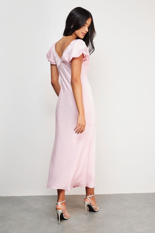 Elegant satin midi tea dress with delicate lace insert detailing
        Feminine puff sleeves with subtle volume for a romantic silhouette
        Flattering V-neckline with charming bow tie detail
        Flowing midi length design that falls gracefully to mid-calf
        Fully lined for comfort and a smooth, refined drape
    
    This enchanting Warehouse tea dress combines vintage-inspired charm with contemporary styling. The satin fabric creates a lustrous finish that catches the light beautifully, whilst the puff sleeves and lace inserts add a touch of feminine flair. Style with strappy metallic sandals as seen on our model for daytime gatherings, or dress down with white trainers and a denim jacket for weekend brunches. The versatile midi length works wonderfully for family celebrations or garden parties-simply add delicate jewellery and a woven clutch to complete the look. For cooler days, layer with a lightweight cardigan and ankle boots for an effortlessly chic ensemble that transitions seamlessly from day to evening. This dress embodies confident femininity with its subtle details and timeless silhouette.