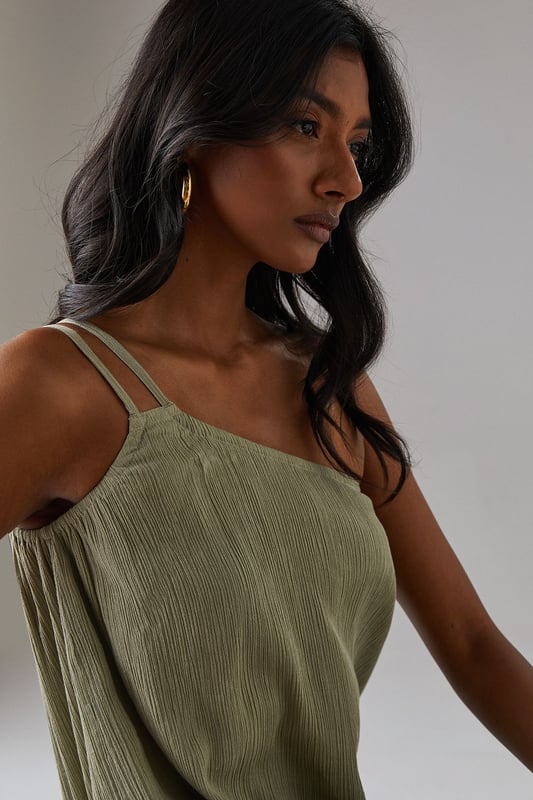 Asymmetric one-shoulder design with elegant double strap detail
        Lightweight cheesecloth fabric creates a breezy, effortless drape
        Flowing maxi length with feminine tiered hem detail
        Relaxed silhouette offers comfortable movement for all-day wear
        Versatile sundress that transitions seamlessly from day to evening occasions
    
    This striking Warehouse maxi sundress commands attention with its distinctive asymmetric neckline and double strap detail. The lightweight cheesecloth fabric creates a beautifully fluid silhouette that moves gracefully with every step, while the tiered hem adds a touch of feminine flair. For formal occasions, style with metallic strappy heels and statement gold jewellery as seen on our model - the chunky bangle creates a perfect contrast against the dress's soft texture. Alternatively, embrace a more relaxed daytime look with leather sandals and a woven clutch. The versatile design makes it an ideal choice for summer weddings, garden parties, or sophisticated evening events where you wish to project confidence with an edgy yet feminine aesthetic. The one-shoulder design offers a contemporary twist on classic occasion wear, ensuring you stand out for all the right reasons.