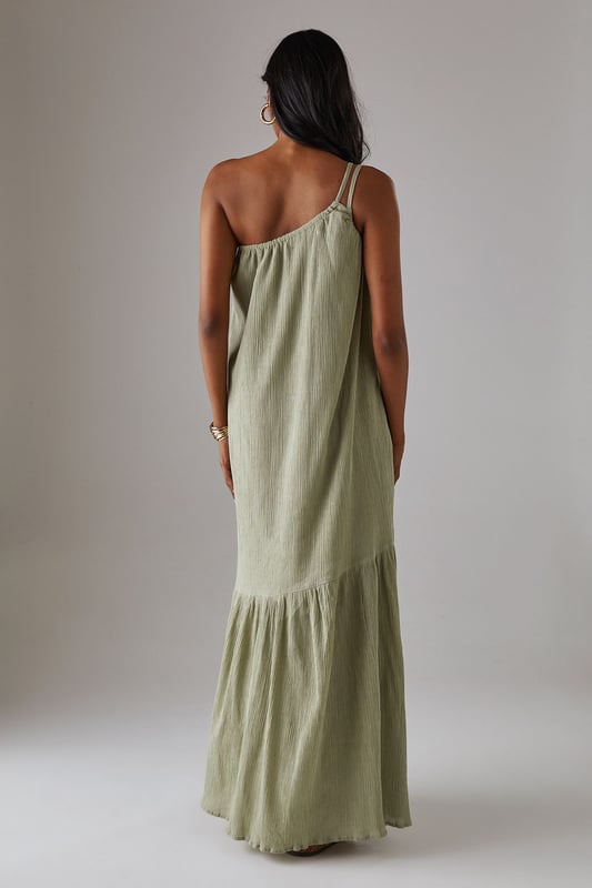 Asymmetric one-shoulder design with elegant double strap detail
        Lightweight cheesecloth fabric creates a breezy, effortless drape
        Flowing maxi length with feminine tiered hem detail
        Relaxed silhouette offers comfortable movement for all-day wear
        Versatile sundress that transitions seamlessly from day to evening occasions
    
    This striking Warehouse maxi sundress commands attention with its distinctive asymmetric neckline and double strap detail. The lightweight cheesecloth fabric creates a beautifully fluid silhouette that moves gracefully with every step, while the tiered hem adds a touch of feminine flair. For formal occasions, style with metallic strappy heels and statement gold jewellery as seen on our model - the chunky bangle creates a perfect contrast against the dress's soft texture. Alternatively, embrace a more relaxed daytime look with leather sandals and a woven clutch. The versatile design makes it an ideal choice for summer weddings, garden parties, or sophisticated evening events where you wish to project confidence with an edgy yet feminine aesthetic. The one-shoulder design offers a contemporary twist on classic occasion wear, ensuring you stand out for all the right reasons.