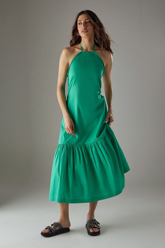Crafted from breathable cotton poplin fabric for all-day comfort
        Delicate crochet trim detailing along the halterneck neckline adds a feminine touch
        Flattering drop waist silhouette with a relaxed midi length
        Elegant tiered hem creates movement and dimension
        Thin halter straps with back fastening for an adjustable fit
    
    This Warehouse sundress combines effortless style with practical comfort for warm-weather dressing. The relaxed drop waist silhouette creates a carefree aesthetic while the crochet trim adds a touch of artisanal detail to the halterneck design. Style with flat sandals and a woven tote for farmers' markets and weekend brunches, or dress up with espadrille wedges and statement earrings for garden parties. The versatile midi length works beautifully for coastal holidays - simply throw over your swimwear with a wide-brimmed hat for beach-to-bar ease. For cooler evenings, layer with a lightweight denim jacket and switch to ankle boots for an extended seasonal wardrobe staple that transitions seamlessly from day to night.