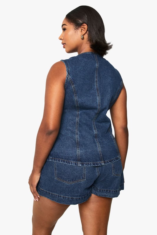 Sleeveless denim waistcoat with round neckline and button-through front closure
        Structured silhouette with flattering seam detailing for a defined shape
        Practical front patch pockets perfect for small essentials
        Versatile layering piece available in plus sizes for inclusive styling
        Classic denim construction offering durability and timeless appeal
    
    This Boohoo Plus lange Denim-Weste brings contemporary edge to your casual wardrobe. The structured waistcoat design creates a flattering silhouette whilst the button-through front allows for versatile styling-wear fully fastened for a polished look or open for a more relaxed vibe. Style with matching denim shorts as shown for a coordinated ensemble, or pair with wide-leg trousers and trainers for weekend brunches. For transitional weather, layer over a fitted long-sleeve top or crisp white shirt. The practical patch pockets add functionality without compromising on style. Perfect for family gatherings, casual outings or festival season, this denim waistcoat works brilliantly with statement sunglasses and a compact handbag to complete your look. A true wardrobe staple that offers endless styling possibilities throughout the seasons.