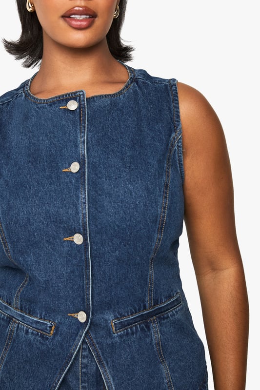 Sleeveless denim waistcoat with round neckline and button-through front closure
        Structured silhouette with flattering seam detailing for a defined shape
        Practical front patch pockets perfect for small essentials
        Versatile layering piece available in plus sizes for inclusive styling
        Classic denim construction offering durability and timeless appeal
    
    This Boohoo Plus lange Denim-Weste brings contemporary edge to your casual wardrobe. The structured waistcoat design creates a flattering silhouette whilst the button-through front allows for versatile styling-wear fully fastened for a polished look or open for a more relaxed vibe. Style with matching denim shorts as shown for a coordinated ensemble, or pair with wide-leg trousers and trainers for weekend brunches. For transitional weather, layer over a fitted long-sleeve top or crisp white shirt. The practical patch pockets add functionality without compromising on style. Perfect for family gatherings, casual outings or festival season, this denim waistcoat works brilliantly with statement sunglasses and a compact handbag to complete your look. A true wardrobe staple that offers endless styling possibilities throughout the seasons.