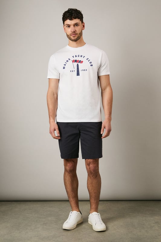 Classic crew neck t-shirt featuring the distinctive Maine Yacht Club graphic print
        Short sleeves with neat ribbed trim for a clean finish
        Soft jersey fabric offering comfort for all-day wear
        Vintage-inspired nautical design with established date detail
        Relaxed fit that's perfect for casual styling
    
    This Maine Yacht Club t-shirt combines timeless nautical charm with everyday wearability. The distinctive graphic print adds character to your casual collection, whilst the comfortable jersey fabric ensures it remains a go-to piece for relaxed days. Style as seen with dark shorts and white trainers for a classic summer look that works brilliantly for weekend brunches or coastal walks. For cooler evenings, layer under a lightweight bomber jacket or denim shirt. This versatile t-shirt transitions effortlessly from daytime casual to evening gatherings with friends - simply swap the shorts for chinos and add a casual blazer to create a smart-casual ensemble that maintains its laid-back appeal. Perfect for holidays, festivals or simply enjoying the British summer.