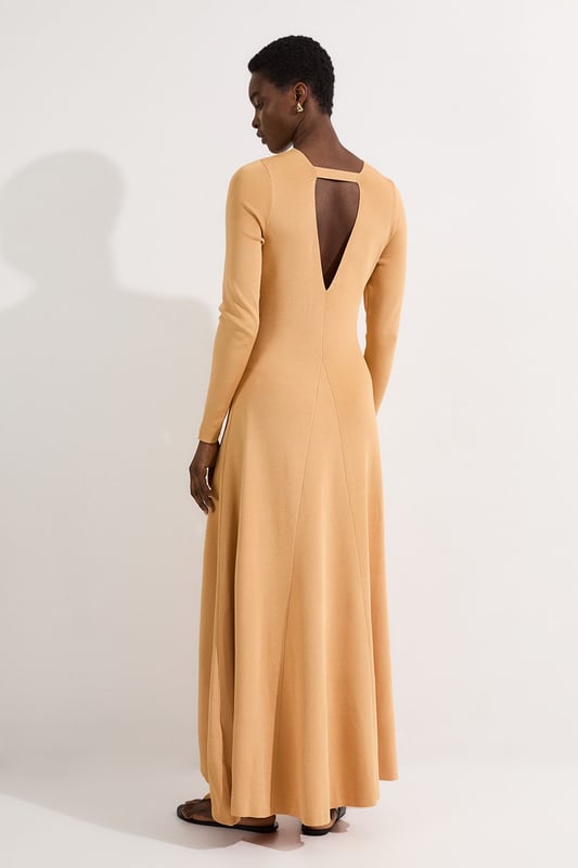 Make a statement at your next formal occasion with this captivating Karen Millen slinky knitted dress. The deep V neckline adorned with the signature hardware keyring detail creates a focal point that draws the eye, whilst the fluid knitted fabric drapes beautifully over your curves. Style with strappy metallic heels and a structured clutch for evening events, or dress down with embellished flat sandals for sophisticated daytime gatherings. The versatile design transitions seamlessly from wedding guest attire to race day ensemble, with the long sleeves offering coverage for cooler evening affairs. Add statement earrings and a sleek updo to showcase the elegant neckline, completing a look that commands attention whilst maintaining refined sophistication.  Striking V neckline with distinctive hardware keyring detail for a contemporary edge Elegant long sleeves with contrasting metallic accent detailing at the cuffs Flattering slinky knitted fabric that gracefully contours the silhouette Sophisticated maxi length with a subtle asymmetric hemline Figure-enhancing fit that creates a refined feminine profile