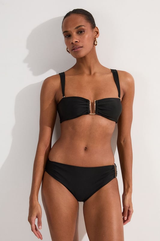 These sophisticated Karen Millen bikini bottoms bring a touch of luxury to your beachwear collection. The striking gold trim adds a refined accent that catches the light beautifully as you lounge poolside or stroll along the shore. Pair with the coordinating bandeau top for a cohesive look that's perfect for your summer getaway. Style with oversized sunglasses and a flowing kaftan for elegant poolside glamour, or team with a linen shirt and sandals when heading to a beachside lunch. These bottoms offer the perfect balance of comfort and sophistication for your next sun-soaked holiday.   Distinctive gold-tone trim detail on the side Mid-rise design offering comfortable coverage and a flattering silhouette Soft, stretchy fabric Sleek, minimalist design that pairs beautifully with the matching bandeau top  Matching piece sold separately.