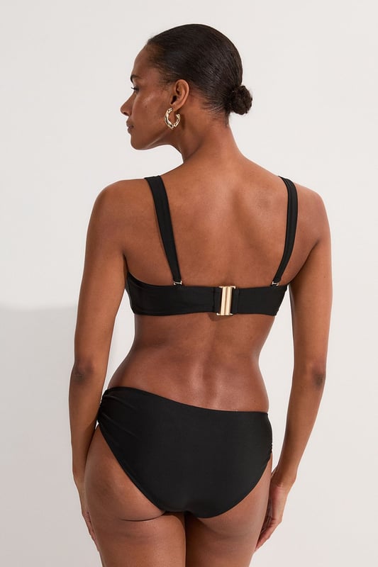 These sophisticated Karen Millen bikini bottoms bring a touch of luxury to your beachwear collection. The striking gold trim adds a refined accent that catches the light beautifully as you lounge poolside or stroll along the shore. Pair with the coordinating bandeau top for a cohesive look that's perfect for your summer getaway. Style with oversized sunglasses and a flowing kaftan for elegant poolside glamour, or team with a linen shirt and sandals when heading to a beachside lunch. These bottoms offer the perfect balance of comfort and sophistication for your next sun-soaked holiday.   Distinctive gold-tone trim detail on the side Mid-rise design offering comfortable coverage and a flattering silhouette Soft, stretchy fabric Sleek, minimalist design that pairs beautifully with the matching bandeau top  Matching piece sold separately.