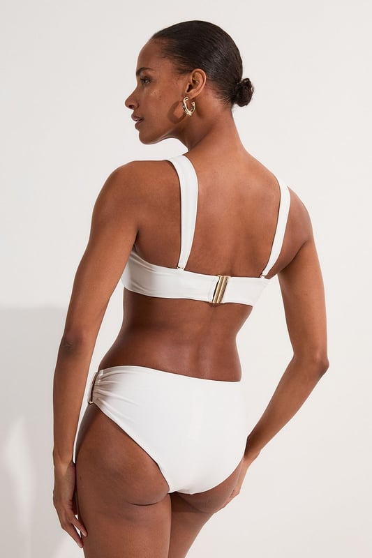 These sophisticated Karen Millen bikini bottoms bring a touch of luxury to your beachwear collection. The striking gold trim adds a refined accent that catches the light beautifully as you lounge poolside or stroll along the shore. Pair with the coordinating bandeau top for a cohesive look that's perfect for your summer getaway. Style with oversized sunglasses and a flowing kaftan for elegant poolside glamour, or team with a linen shirt and sandals when heading to a beachside lunch. These bottoms offer the perfect balance of comfort and sophistication for your next sun-soaked holiday.   Distinctive gold-tone trim detail on the side Mid-rise design offering comfortable coverage and a flattering silhouette Soft, stretchy fabric Sleek, minimalist design that pairs beautifully with the matching bandeau top  Matching piece sold separately.