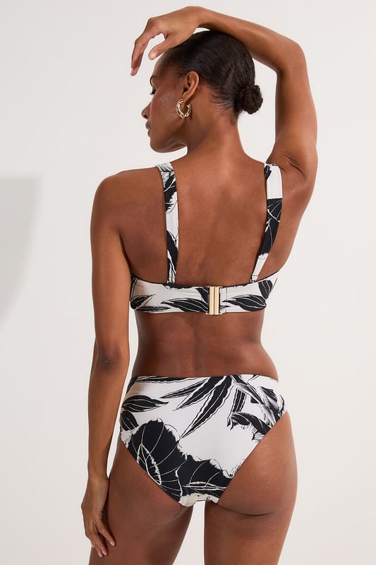 Make a statement this summer with these eye-catching high-waisted bikini bottoms from Karen Millen. The striking palm print design brings a touch of exotic flair to your beach ensemble, whilst the high-waisted cut elongates your legs and accentuates your curves. The gold-toned buckle detail adds a luxurious touch, perfect for those who love a bit of glamour by the pool. Pair with the matching top for a coordinated look, or mix and match with a solid-coloured bandeau for versatility. These bottoms are ideal for sunbathing, beach volleyball, or sipping cocktails at the resort bar. Whether you're jetting off to a tropical paradise or enjoying a staycation, these bikini bottoms will ensure you look and feel fabulous.  High-waisted design for a flattering silhouette Bold palm print pattern for a tropical vibe Decorative gold-toned buckle detail on the side Wide waistband for added comfort and support Moderate coverage at the back for confidence   Matching piece sold separately.