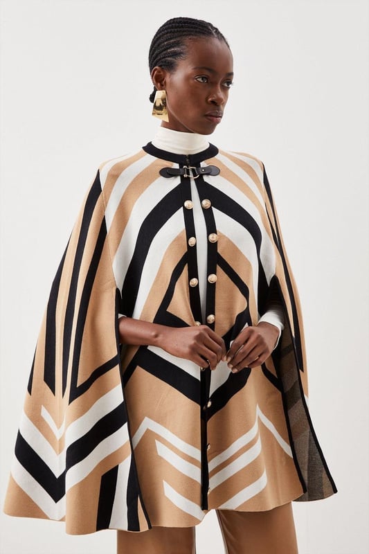 Nothing spells the changing of the seasons like a sleek cape. This covetable design is perfect for all your autumnal adventures, featuring an equestrian-style buckle fastening and cosy, knitted construction. Glossy military-inspired buttons line the front, adding to its luxe allure ? simply slip it on over your outfit for an instantly polished finish. Style: CapeDesign: PlainFabric: KnittedLength: RegularNeckline: CollarlessSleeve Length: Sleeveless Discover our blog post on the most popular coats & jackets for AW24 here.